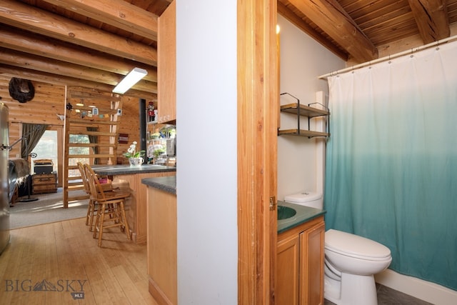 bathroom featuring wooden ceiling, hardwood / wood-style flooring, toilet, rustic walls, and beamed ceiling