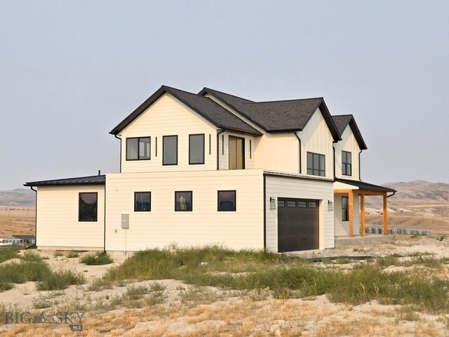 view of property exterior with a mountain view and a garage