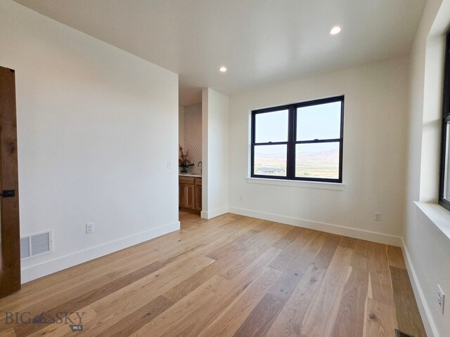 unfurnished room with light wood-type flooring