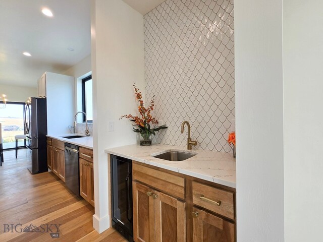 kitchen featuring dishwasher, light hardwood / wood-style floors, stainless steel refrigerator, sink, and beverage cooler