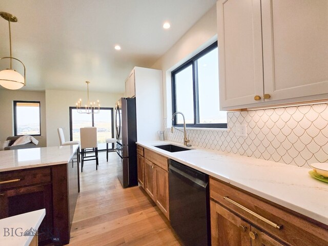 kitchen with decorative light fixtures, black appliances, light hardwood / wood-style flooring, sink, and white cabinets