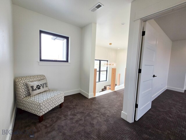 sitting room featuring dark carpet and a notable chandelier