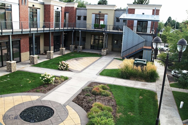 exterior space featuring a balcony and an outdoor fire pit