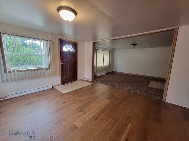 foyer entrance featuring hardwood / wood-style floors and a baseboard heating unit