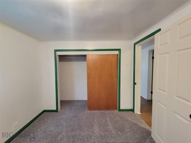 unfurnished bedroom featuring ornamental molding, carpet, and a closet