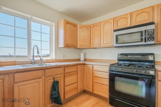 285 Mt Highway 55, Whitehall, MT 59759 - kitchen featuring light countertops, a sink, stainless steel microwave, black range with gas stovetop, and light brown cabinets