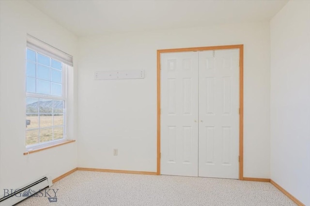 285 Mt Highway 55, Whitehall, MT 59759 - unfurnished bedroom featuring baseboard heating, baseboards, a closet, and light colored carpet