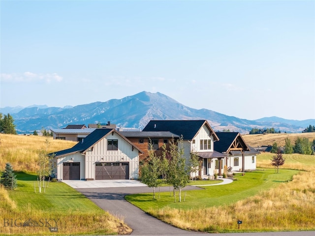 view of front of house with a garage, a mountain view, and a front yard