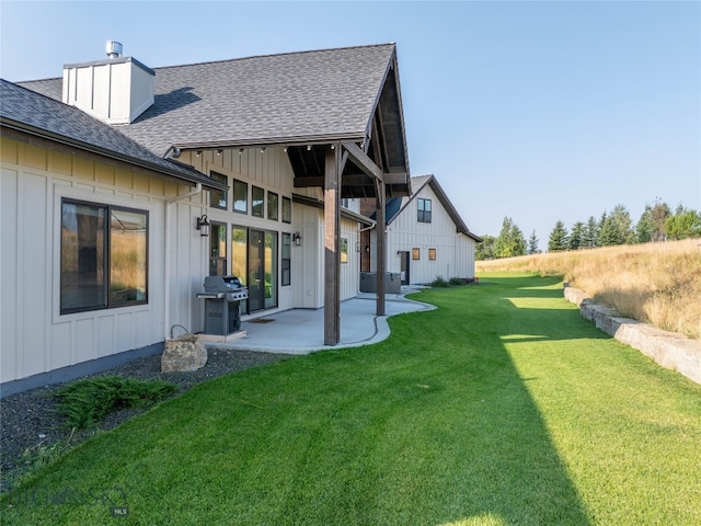 rear view of house featuring a lawn and a patio area