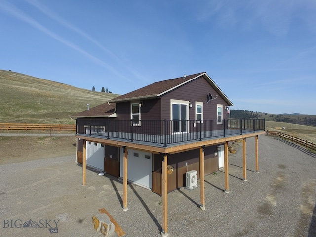 view of front of house featuring a deck, a rural view, and ac unit