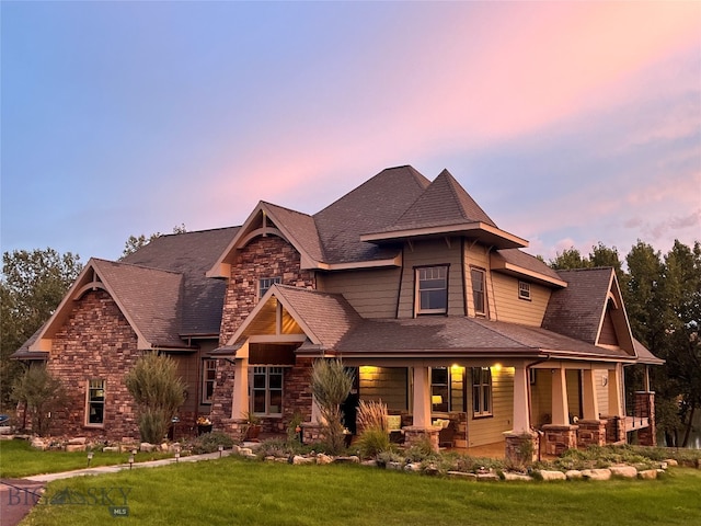 view of front of property featuring covered porch and a lawn