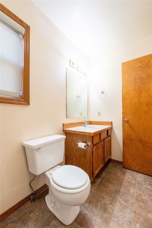 bathroom featuring tile patterned flooring, vanity, and toilet