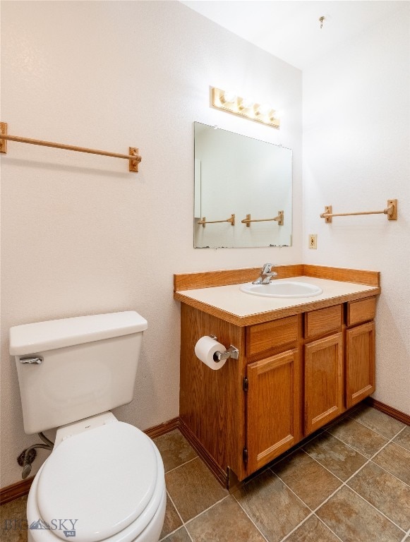 bathroom featuring tile patterned floors, vanity, and toilet