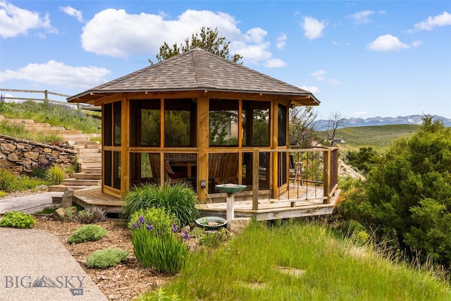 rear view of house featuring a mountain view and a gazebo