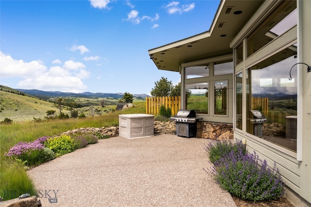 view of patio / terrace featuring a rural view, a mountain view, and a grill