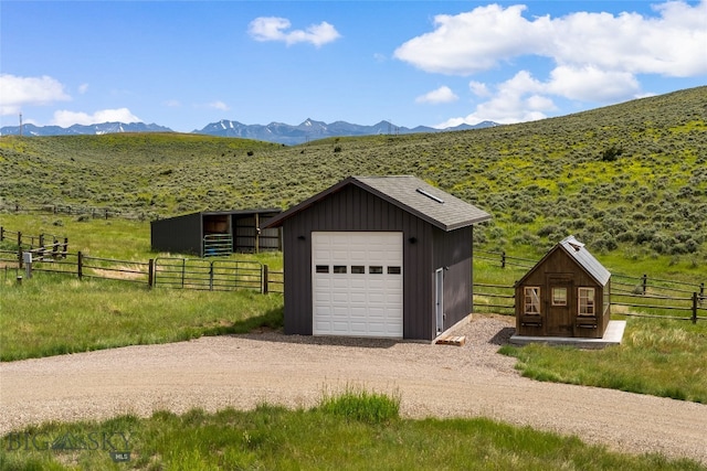 garage with a rural view and a mountain view