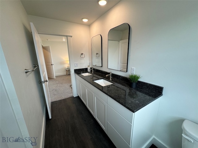 bathroom with hardwood / wood-style floors, vanity, and toilet