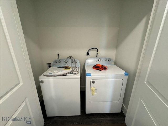 clothes washing area featuring washer and dryer and dark wood-type flooring