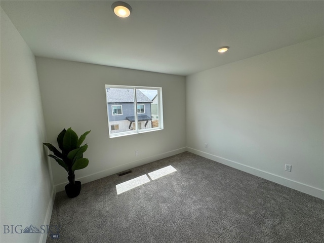 unfurnished room featuring dark carpet