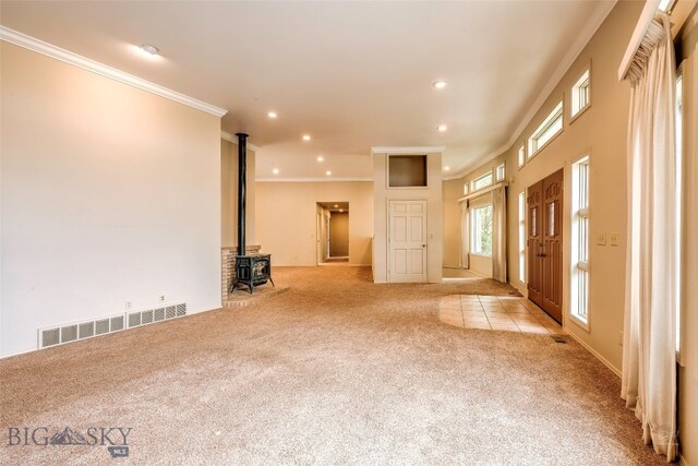 interior space featuring a wood stove, crown molding, and light colored carpet