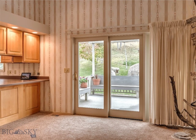 doorway to outside featuring light colored carpet