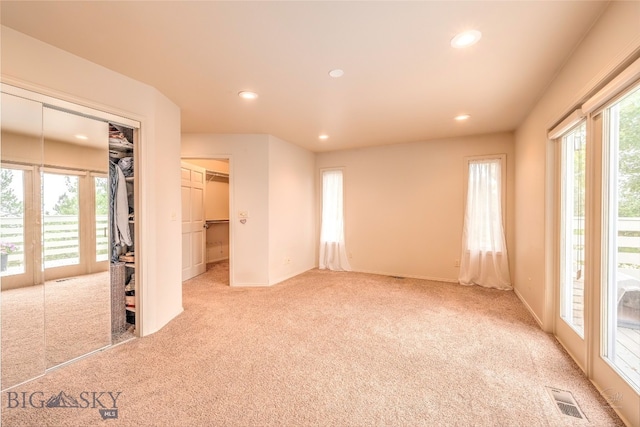empty room featuring french doors, light colored carpet, and a wealth of natural light