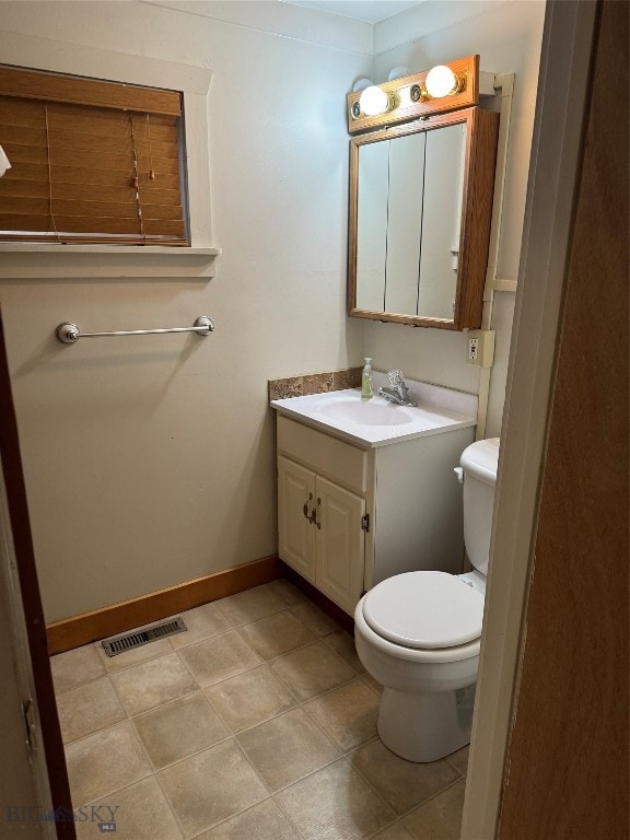 bathroom with tile patterned flooring, vanity, and toilet