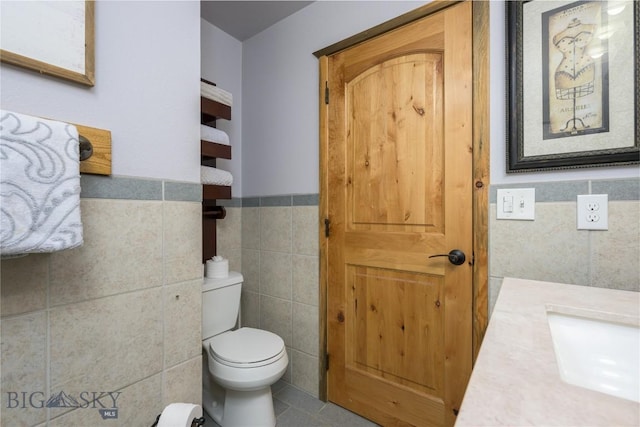 310 Highpark Dr, Anaconda, MT 59711 - bathroom featuring tile walls, toilet, wainscoting, tile patterned flooring, and vanity