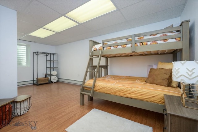 310 Highpark Dr, Anaconda, MT 59711 - bedroom featuring a baseboard heating unit, a paneled ceiling, and wood finished floors