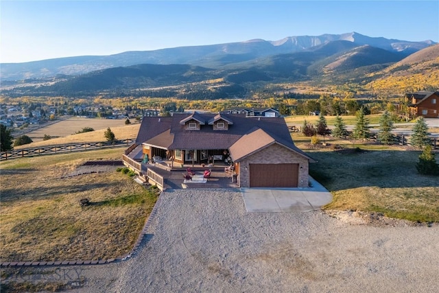 310 Highpark Dr, Anaconda, MT 59711 - view of front of house featuring gravel driveway, covered porch, a mountain view, and an attached garage