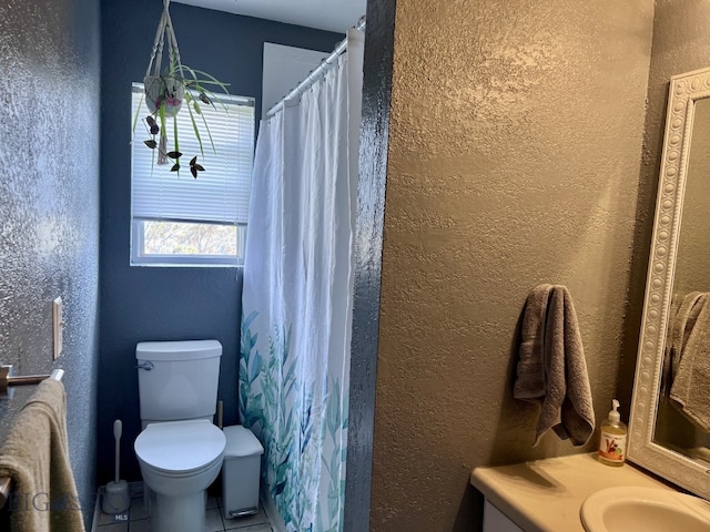 bathroom featuring vanity, tile patterned floors, and toilet