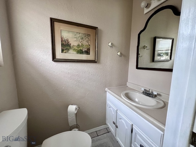 bathroom with tile patterned flooring, vanity, and toilet