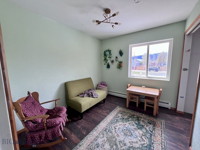 sitting room with an inviting chandelier, dark hardwood / wood-style flooring, and a baseboard heating unit