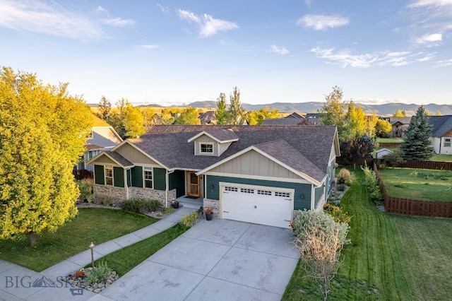 craftsman house featuring a mountain view, a garage, and a front lawn