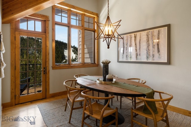 dining space featuring wood-type flooring, lofted ceiling with beams, and a chandelier