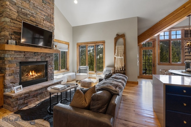 living room with a stone fireplace, light wood-type flooring, and a wealth of natural light