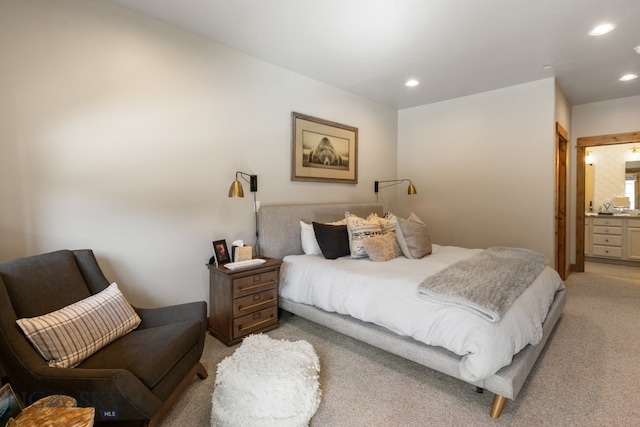 bedroom with connected bathroom and light colored carpet