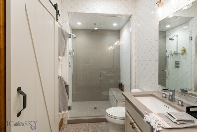 bathroom with vanity, toilet, and a shower with door