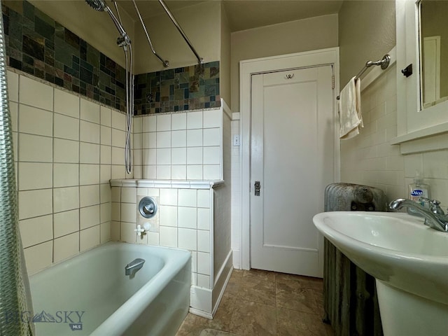 bathroom with tile walls, sink, and shower / bathtub combination with curtain