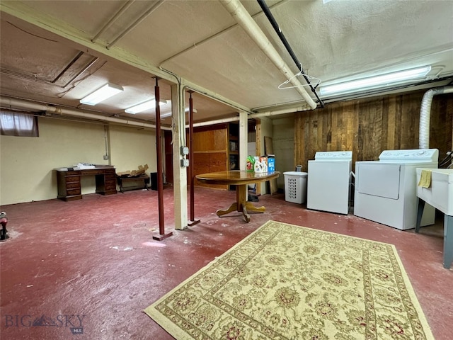 basement with wooden walls and independent washer and dryer