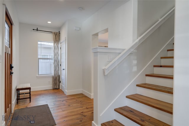 staircase with a wealth of natural light and hardwood / wood-style floors