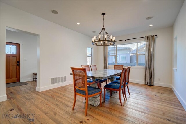 dining space with a chandelier and light hardwood / wood-style floors