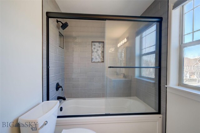 bathroom with enclosed tub / shower combo and toilet