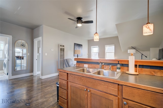 kitchen featuring ceiling fan, pendant lighting, sink, dark hardwood / wood-style floors, and washer / dryer