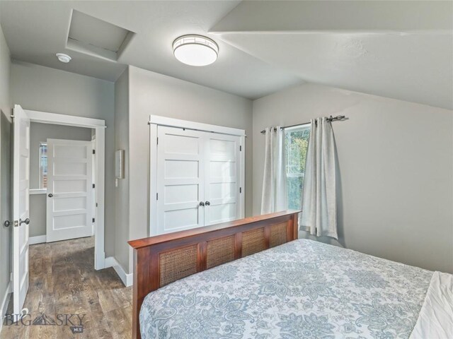 bathroom with vanity, stacked washer and clothes dryer, baseboard heating, walk in shower, and vaulted ceiling