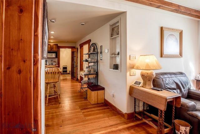 corridor featuring built in features and light hardwood / wood-style flooring