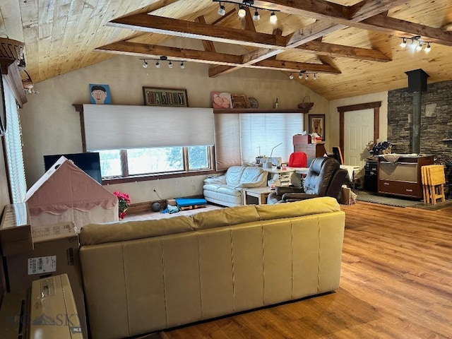 living room featuring light hardwood / wood-style floors, wood ceiling, a wood stove, rail lighting, and vaulted ceiling with beams