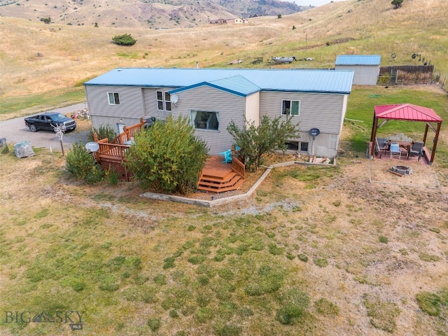 rear view of house featuring a shed, a deck with mountain view, and a gazebo