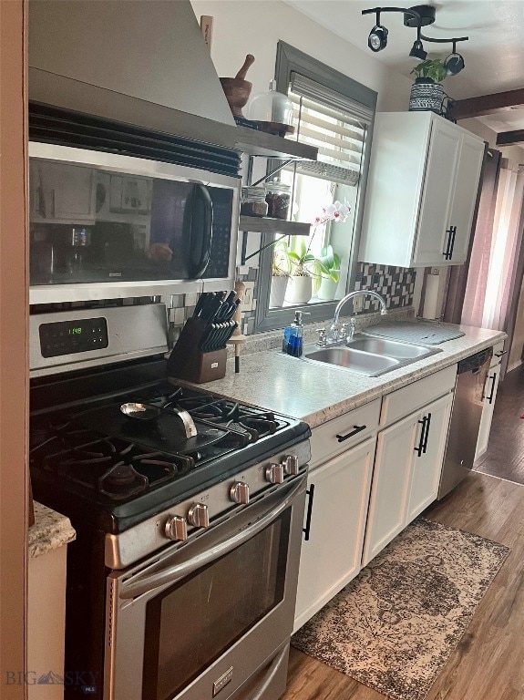 kitchen featuring stainless steel appliances, white cabinetry, sink, tasteful backsplash, and dark hardwood / wood-style floors