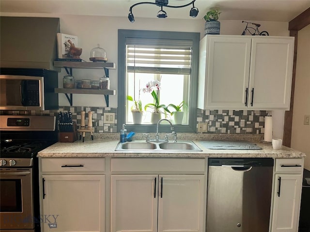 kitchen featuring backsplash, appliances with stainless steel finishes, sink, and white cabinets